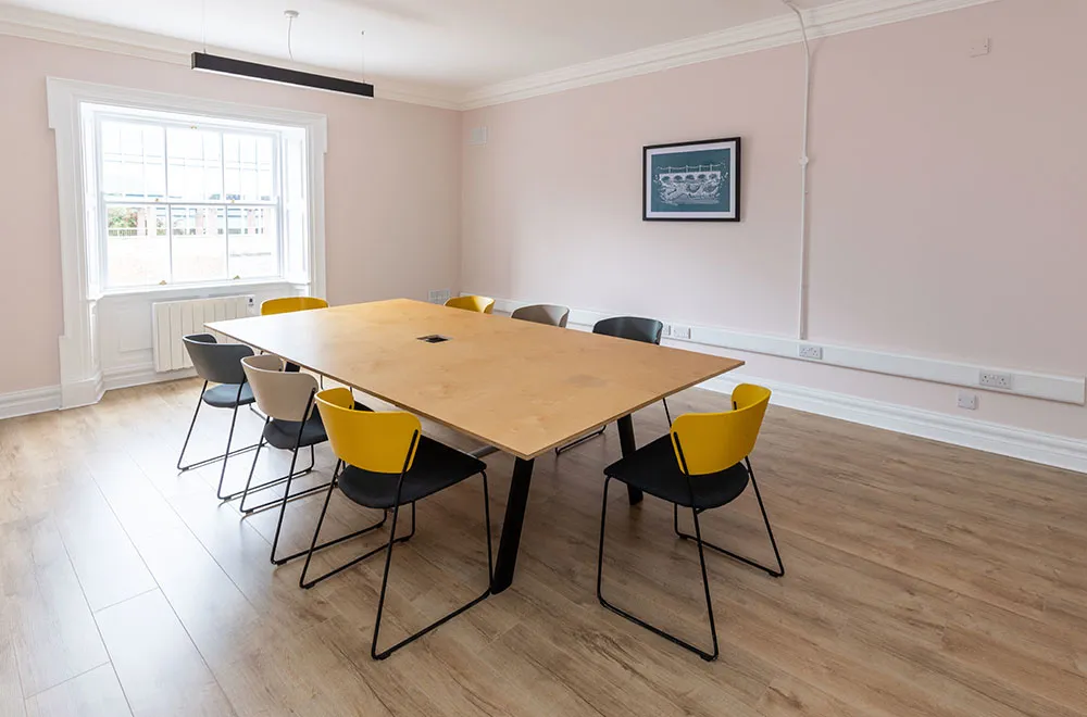A team office with desks by the sash windows